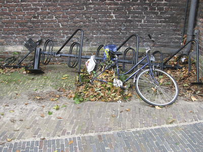 872005 Afbeelding van een gedemonteerd fietsenrek met een fietswrak dat al maandenlang tegen de noordgevel van de ...